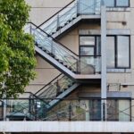Exterior view of a residential building with glass and metal stairs.