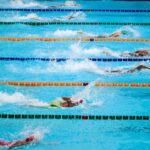 Swimmers compete in an outdoor pool race, showcasing athleticism and sportsmanship.